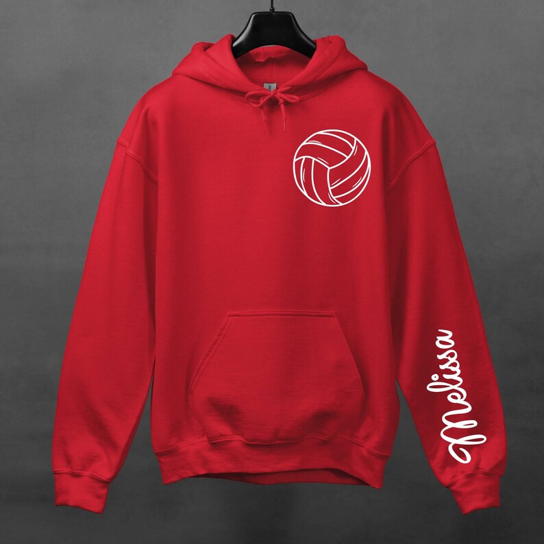 May include: Red hooded sweatshirt with a white volleyball graphic on the front and the name "Melissa" written vertically on the right sleeve.