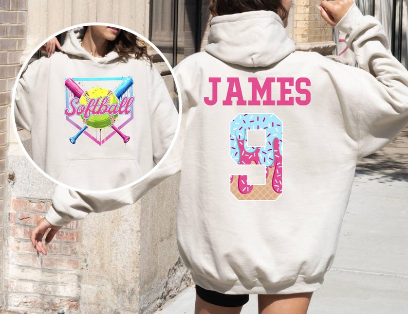 May include: White hoodie with a pink and blue softball design on the front and the text "Softball" and a pink and blue ice cream cone design with the number "9" and the name "JAMES" on the back.