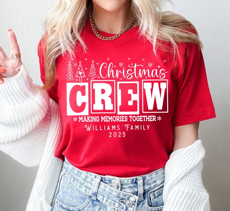 May include: A red t-shirt with the words "Christmas Crew" in white block letters. The shirt also features the text "Making Memories Together" and "Williams Family 2025". Festive Christmas tree and snowflake graphics are also included.