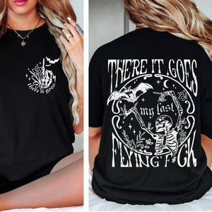 K&ouml;nnte beinhalten: Schwarzes T-Shirt mit einem wei&szlig;en Grafikdruck eines Skeletts, das eine Fledermaus h&auml;lt, und dem Text "There it goes my last flying f*ck".
