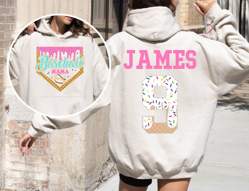 K&ouml;nnte beinhalten: Wei&szlig;er Hoodie mit einem rosafarbenen Baseball-Motiv auf der Vorderseite und dem Namen "JAMES" und der Nummer "9" auf der R&uuml;ckseite. Das Motiv zeigt ein Baseballfeld mit einem tropfenden Eiswaffel und Streuseln.