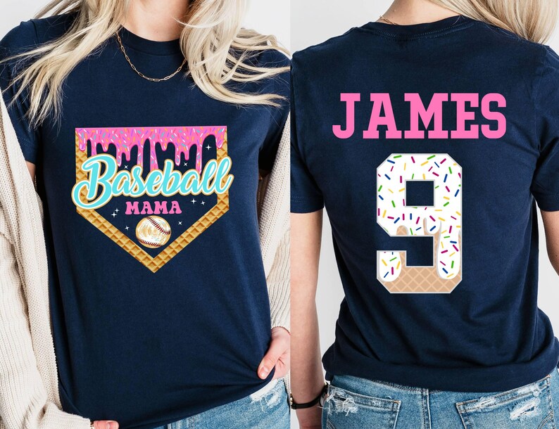 May include: Two navy blue t-shirts. The front shirt has a pink, white, and blue baseball-themed graphic with the text "Baseball Mama". The back shirt has the name "JAMES" and the number "9" in pink with a white and colorful ice cream cone design.