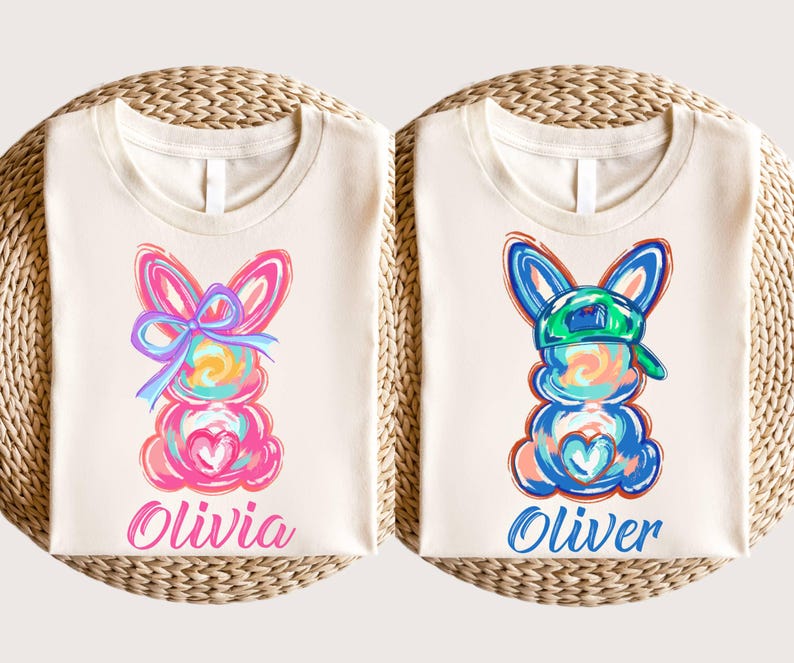 May include: Two white t-shirts with colorful bunny illustrations and names "Olivia" and "Oliver" printed on them.