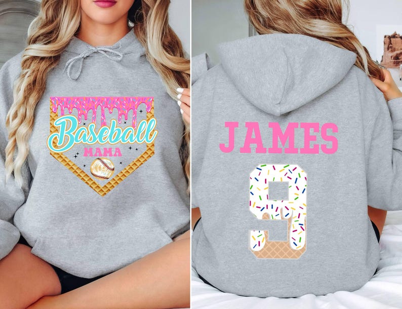 K&ouml;nnte beinhalten: Grauer Kapuzenpullover mit einem rosafarbenen Baseball-Motiv auf der Vorderseite und dem Namen "JAMES" sowie der Nummer "9" mit einem rosafarbenen und wei&szlig;en Zuckerguss auf der R&uuml;ckseite.