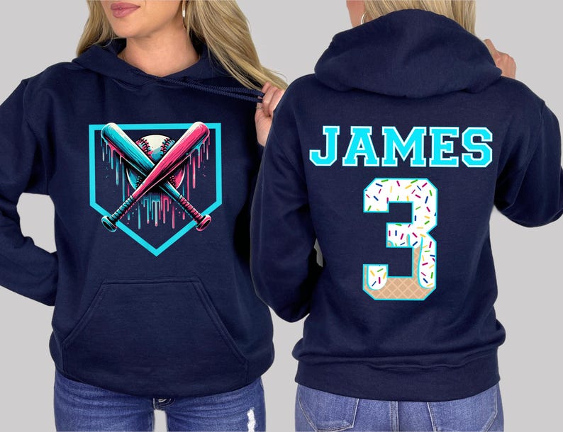 May include: Navy blue hoodie featuring a baseball-themed graphic. The front displays crossed bats and a baseball within a home plate outline. The back has the name "JAMES" and the number "3" with a sprinkle and ice cream cone design.