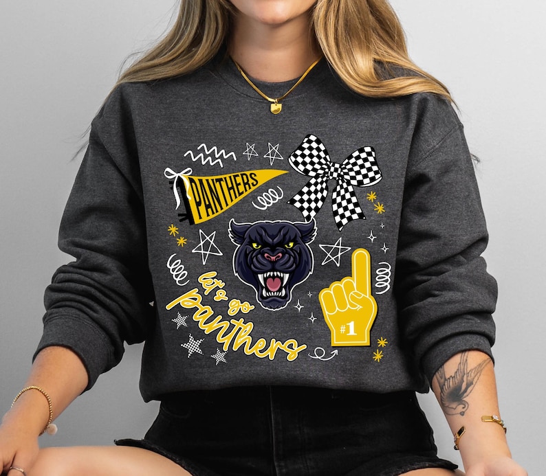 May include: Dark gray sweatshirt with a graphic design featuring a black panther, a checkered bow, and a foam finger. The text "PANTHERS" and "Let's go Panthers" are also included in the design.