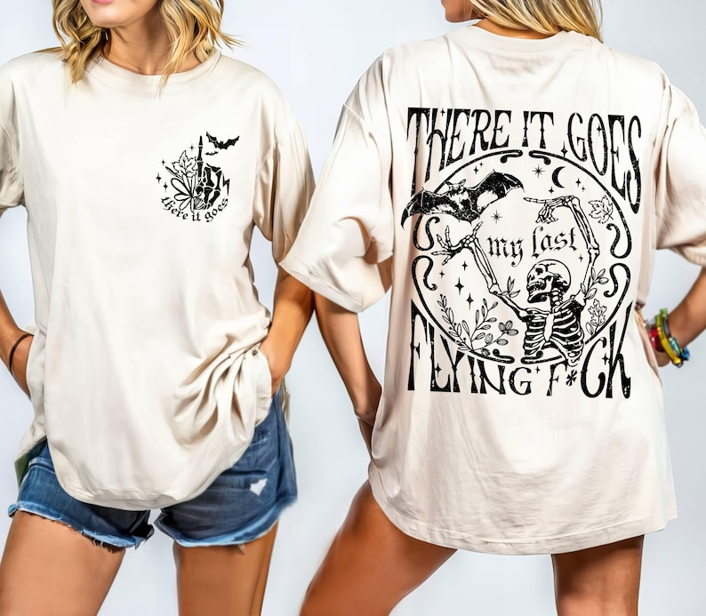 K&ouml;nnte beinhalten: Ein beiges T-Shirt mit einem schwarzen grafischen Aufdruck auf Vorder- und R&uuml;ckseite. Der vordere Aufdruck lautet "There it goes" und der hintere Aufdruck lautet "There it goes my last flying f*ck".
