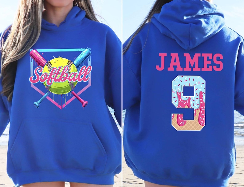 May include: A royal blue hoodie with a softball graphic on the front and the name "JAMES" and the number "9" on the back. The number is decorated with a blue and pink ice cream design.