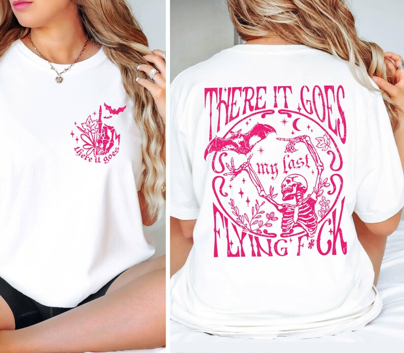 K&ouml;nnte beinhalten: Wei&szlig;es T-Shirt mit einem rosafarbenen Grafikdruck auf Vorder- und R&uuml;ckseite. Die Vorderseite zeigt den Aufdruck "there it goes" mit einer kleinen Fledermaus und Blumen. Die R&uuml;ckseite zeigt den Aufdruck "There it goes my last flying f*ck" mit einem Skelett, das eine Fledermaus und Blumen h&auml;lt.