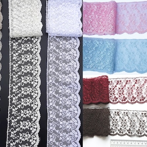 Könnte beinhalten: Sortiment an Spitzenborten in verschiedenen Farben, darunter Beige, Weiß, Rosa, Blau, Rot und Braun. Die Spitze hat ein zartes Blumenmuster mit gewellten Kanten.