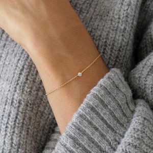 Peut inclure: Un bracelet délicat en chaîne dorée avec un petit diamant.