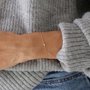 Pu&ograve; includere: Un braccialetto delicato a catena d'oro con un piccolo diamante.