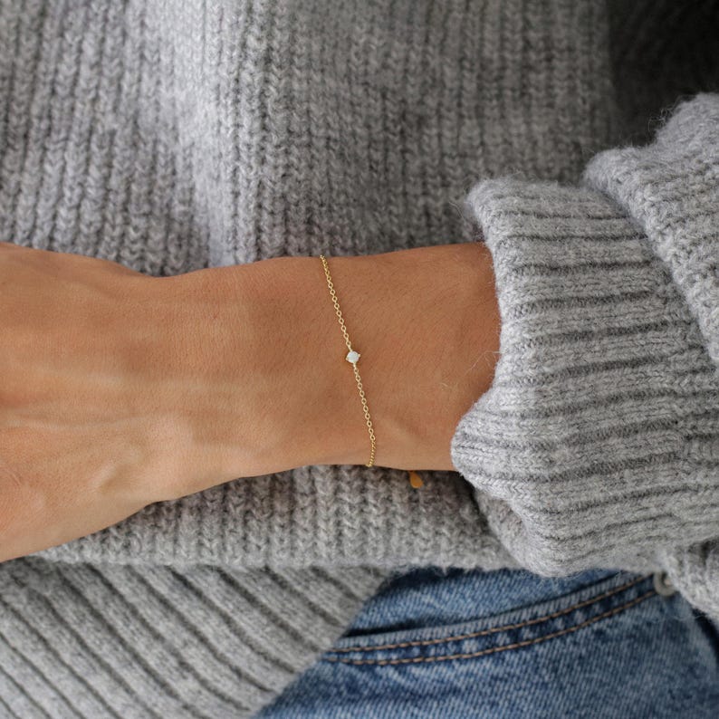 Pu&ograve; includere: Un braccialetto delicato a catena d'oro con un piccolo diamante.