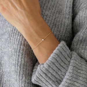 以下が含まれることがあります： 小さなダイヤモンドがあしらわれた繊細なゴールドチェーンブレスレット