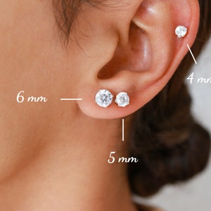 Pu&ograve; includere: Tre paia di orecchini a perno d'argento con pietre di zircone cubico trasparenti. Gli orecchini hanno un diametro di 4 mm, 5 mm e 6 mm.
