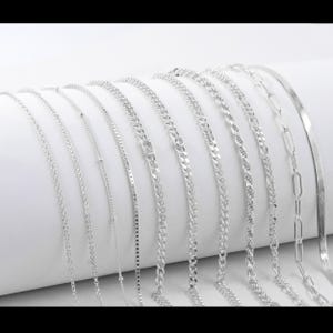 Puede incluir: Una colecci&oacute;n de cadenas de plata de diferentes estilos y grosores. Las cadenas est&aacute;n dispuestas en una fila, con la cadena m&aacute;s gruesa en la parte superior y la cadena m&aacute;s fina en la parte inferior.