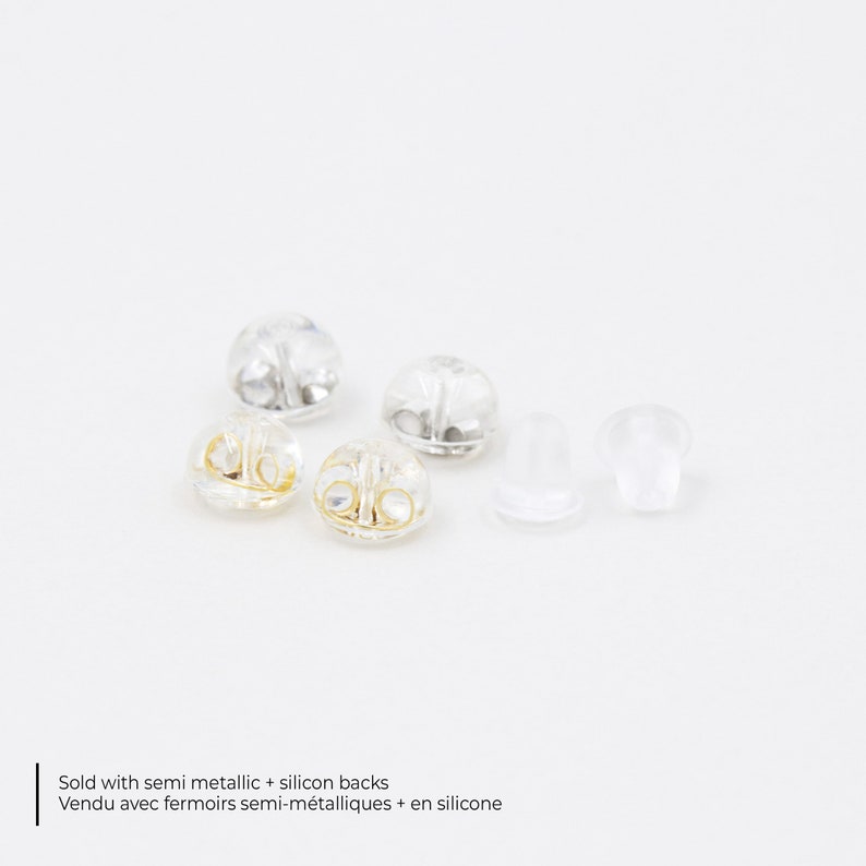 May include: A collection of earring backs, including semi-metallic and clear silicone styles, are displayed against a white background. The image includes text that reads "Sold with semi metallic + silicon backs".