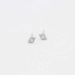May include: A pair of silver diamond earrings with a small diamond in the centre of each earring.