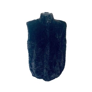 May include: A sleeveless black vest featuring a high collar and a full-length front zipper. The garment is crafted from a textured, plush material with a repeating, wavy, embossed pattern across the entire surface of the fabric.