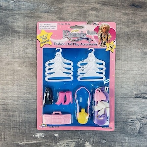 May include: A pink package of Lovely Kimmie fashion doll play accessories. The package includes white hangers, black and pink doll shoes, a pink boombox, a yellow perfume bottle, and a purple purse. The package is labeled "Fits All 11" (29CM) Fashion Dolls".