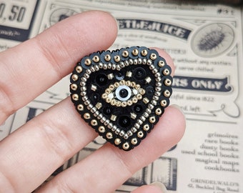 Le Fabularium Black and gold eye heart brooch in pearl and sequin embroidery