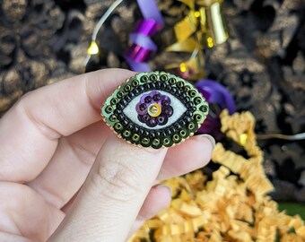 The Fabularium - Purple and green eye brooch embroidered with hand beads