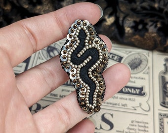 Le Fabularium Black and brown snake brooch in pearls and sequins, hand embroidered.