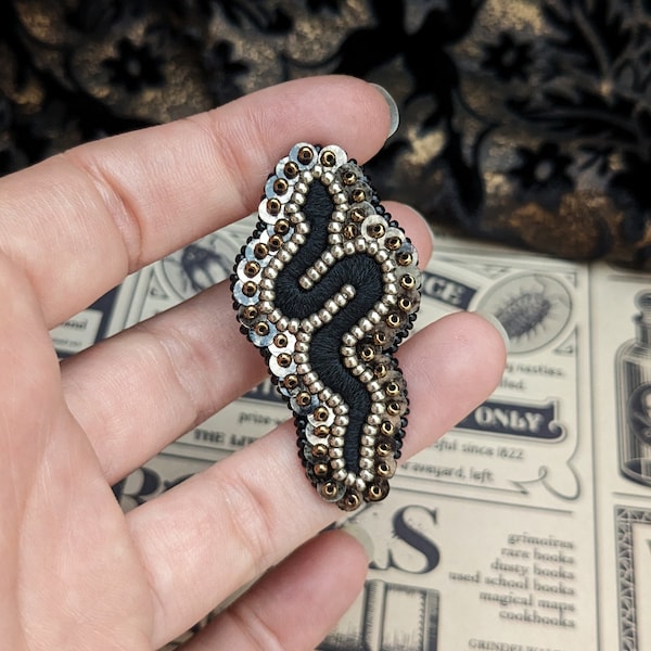 Le Fabularium Broche serpent noir et marron en perles et paillettes brodée à la main.