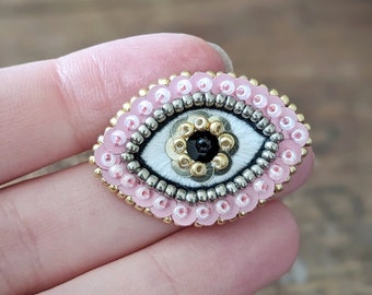 The Fabularium - Broche de ojos rosas bordado con cuentas a mano