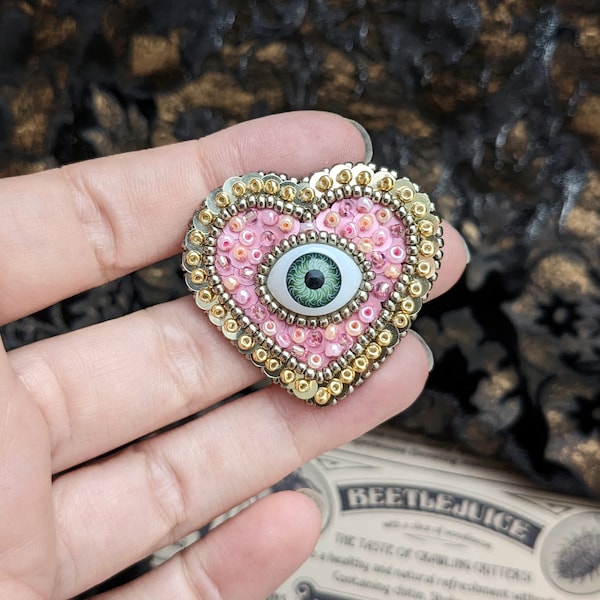 Le Fabularium Broche coeur œil paillettes rose en broderie de perles à la main | Épingle thème pastel goth | Cabinet de curiosités