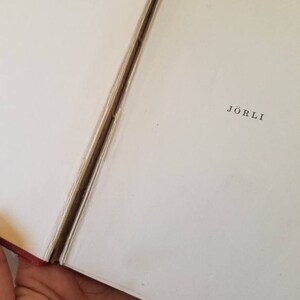 May include: A close-up of the spine of a book with the title "J&ouml;rli" printed in black on a white background.