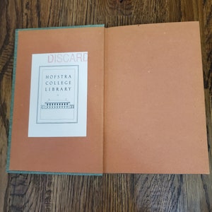Pu&ograve; includere: Un libro verde e arancione con il testo "DISCARD" e "HOFSTRA COLLEGE LIBRARY" sulla copertina.