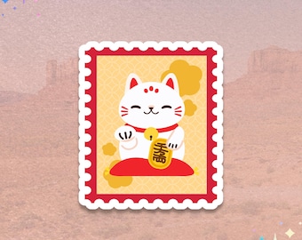 May include: A sticker featuring a white Maneki-neko cat with red accents, holding a gold coin. The cat is seated on a red cushion within a red and yellow postage stamp design. The background is a soft, textured pink.