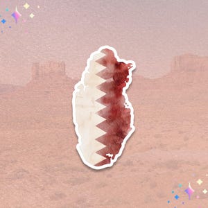May include: A sticker featuring the shape of Qatar, with a watercolor effect. The design incorporates the Qatari flag's colors: white and maroon. The sticker has a white border and is set against a textured, pinkish-brown background.