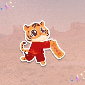 May include: A sticker featuring a cartoon tiger in a red outfit, holding a scroll with Chinese characters. The tiger has orange fur with black stripes and is smiling. The background is a desert landscape.