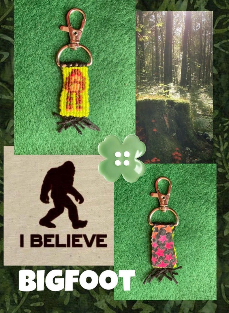 Puede incluir: Dos llaveros tejidos con cierres de mosquet&oacute;n de metal. Uno presenta un fondo amarillo con una figura de Bigfoot marr&oacute;n, el otro tiene un patr&oacute;n de estrellas negras y rosas. Una tarjeta cuadrada muestra una silueta de Bigfoot con el texto I BELIEVE BIGFOOT.