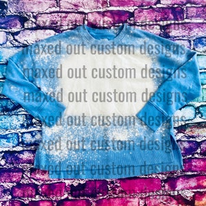 Può includere: Una felpa a maniche lunghe blu brillante con un'ampia area rettangolare centrale sbiancata. Il capo presenta un girocollo, polsini a coste e spacchi laterali sull'orlo. Il testo "maxed out custom designs" è ripetuto su tutta l'immagine.