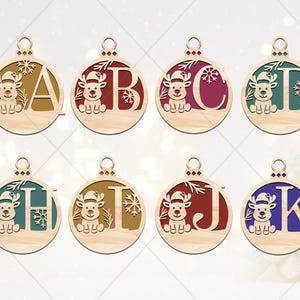 May include: Wooden Christmas ornaments with letters A, B, C, D, H, I, J, and K. Each ornament features a reindeer wearing a Santa hat and snowflakes. The letters are in various colors, including red, green, and blue.