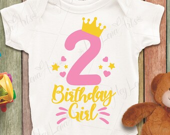 May include: A white onesie with a pink number two and the text "Birthday Girl" in yellow. The number two has a gold crown on top and is surrounded by pink hearts and yellow stars.