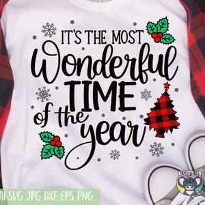 May include: White t-shirt with black text that reads "It's the most Wonderful Time of the Year" with a red and black buffalo plaid Christmas tree and holly berry accents.