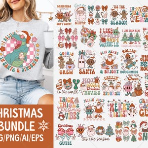 May include: A light gray sweatshirt with a graphic of a dinosaur wearing a Santa hat and the text "I Believe in Santa & Dinosaurs." The image also shows a Christmas bundle with various designs, including text and illustrations.