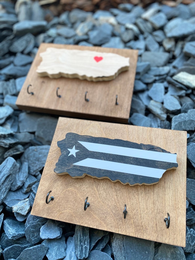 K&ouml;nnte beinhalten: Schl&uuml;sselhalter aus Holz in Form der Insel Puerto Rico mit einem roten Herzen oben und vier Haken unten. Der Schl&uuml;sselhalter ist aus hellbraunem Holz gefertigt und hat eine nat&uuml;rliche Holzoptik.