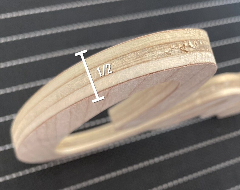 May include: Close-up of the edge of a wooden cutout, showing the layers of plywood. The cutout is 1/2 inch thick.