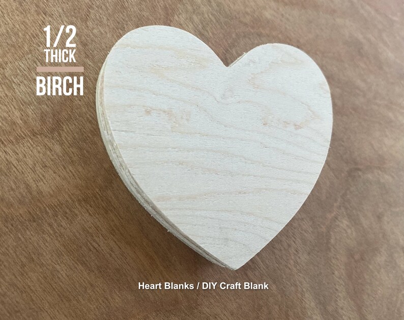 May include: A plain, unfinished, heart-shaped wooden craft blank made from birch wood. It is 1/2 inch thick. The blank is on a brown wooden surface. Heart Blanks / DIY Craft Blank
