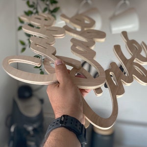 May include: Wooden sign with the words "Love the Coffee" in a cursive font.