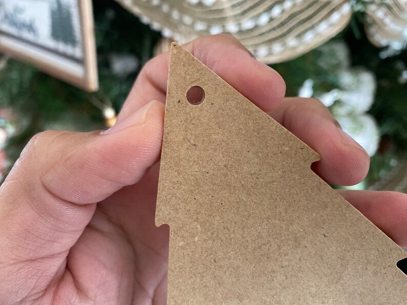May include: A brown cardboard Christmas tree bauble with a hole punched in the top for hanging.