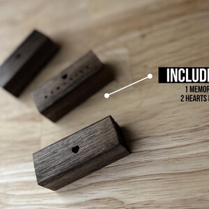 Puede incluir: Tres bloques de madera con diferentes dise&ntilde;os. Un bloque tiene la palabra "Memories" tallada en &eacute;l, y los otros dos bloques tienen formas de coraz&oacute;n talladas en ellos. El texto "INCLUDES 3" es visible sobre los bloques, con el texto "1 MEMORIES AND 2 HEARTS DESIGNS" debajo.
