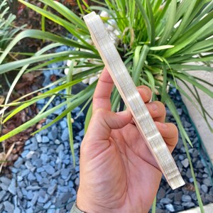 Pode incluir: Uma pilha de t&aacute;buas finas de madeira com acabamento em madeira natural. As t&aacute;buas s&atilde;o mantidas juntas por um adesivo branco fino.