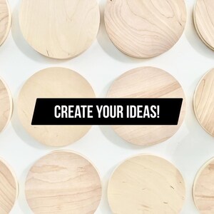 May include: A selection of circular, unfinished wooden plaques displayed against a white background. The natural wood grain is visible on each plaque. A black banner across the center reads "CREATE YOUR IDEAS!"