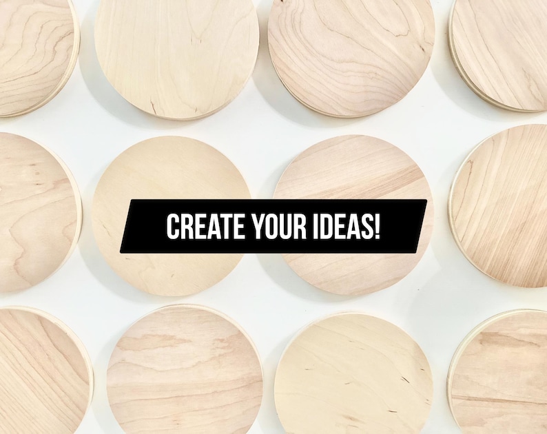 May include: A selection of circular, unfinished wooden plaques displayed against a white background. The natural wood grain is visible on each plaque. A black banner across the center reads "CREATE YOUR IDEAS!"